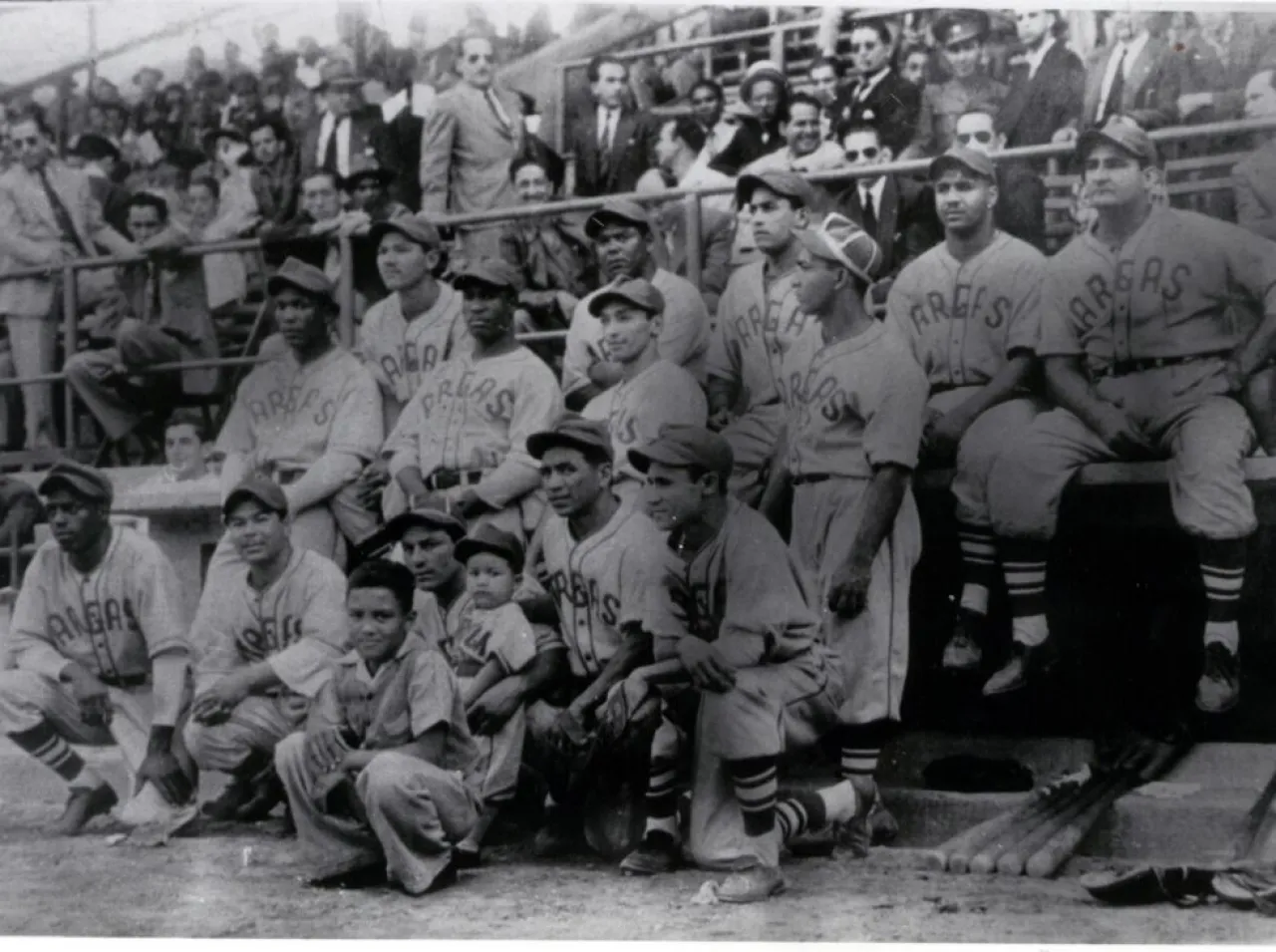 Peloteros de los Sabios del Vargas posan uniformados en las gradas de un estadio durante la época inaugural de la LVBP